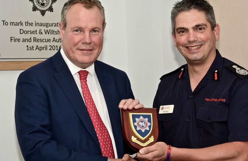 Dorset & Wiltshire Fire Chief Ben Ansell presenting Conor with the shield of the new fire service.