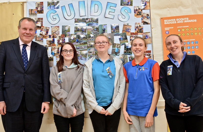Conor pictured with the Girl Guides in front of their activities board.