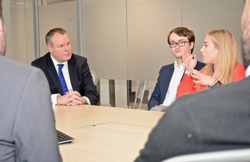 Conor pictured talking with young technology apprentices in a meeting room. 