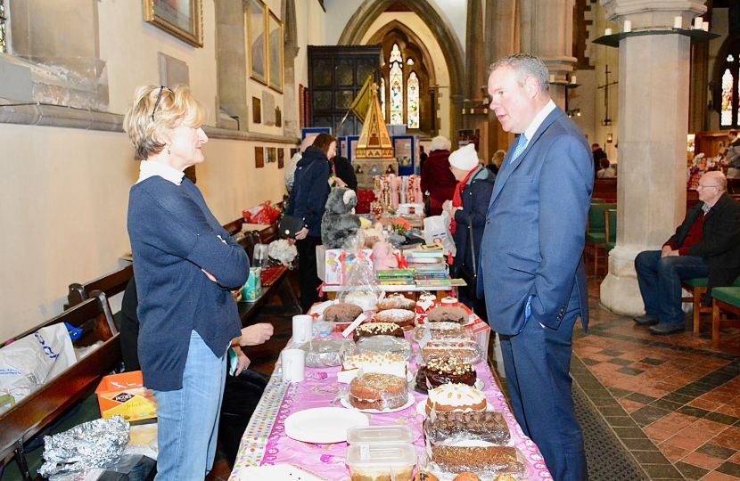 Conor pictured speaking with a St Peter’s Church volunteer on the cake sale table. 