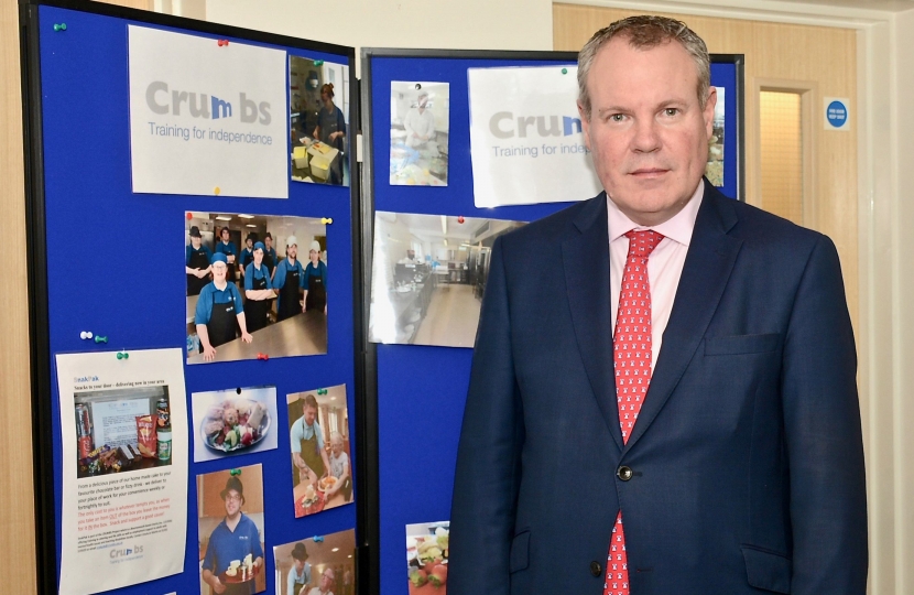 Conor pictured in front of the Crumbs volunteer and achievement board. 