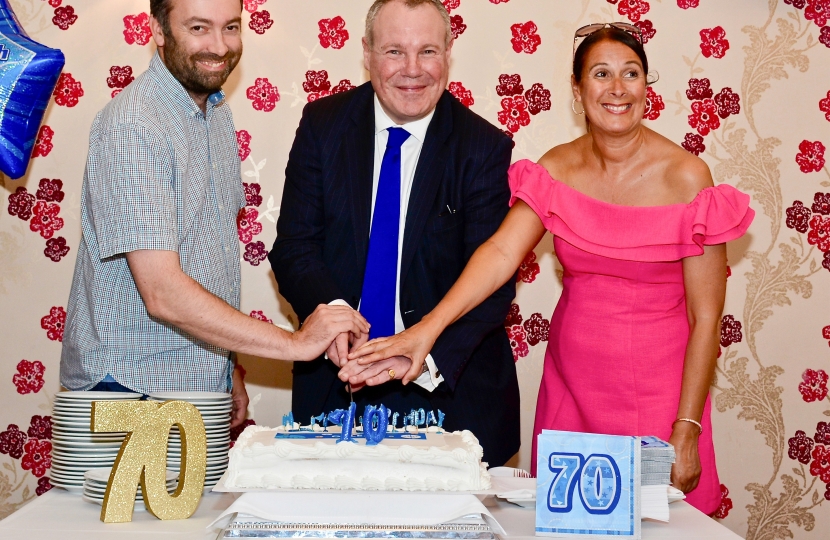 Conor cutting the cake with Sarah England and Matthew Moore.