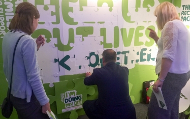 Conor places his part into the Macmillan jigsaw display.