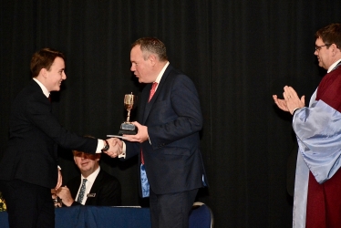 Conor pictured presenting a student with an award for academic excellence. 