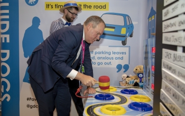 Conor participating in the Guide Dogs' specially-themed whack-a-mole game to illustrate the problem of pavement parking.
