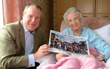 Conor delivers the signed photo to Mrs Bybutt which read “To Hilda, with love.”