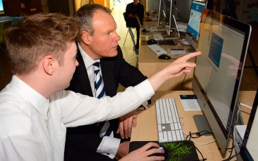 Conor learning how to code as he interacts with a BU student. 